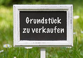 Schild "Grundstück zu verkaufen" auf Rasenfläche. Foto: F. Schmidt/Fotolia.com