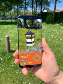 Unsichtbares wird mit der WunderlineGO App auf einer Litfaßsäule sichtbar. Foto: Ostfriesland Tourismus GmbH